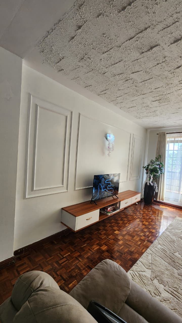 Custom wainscoting installation on a lounge feature wall at a private residence in Kiambu