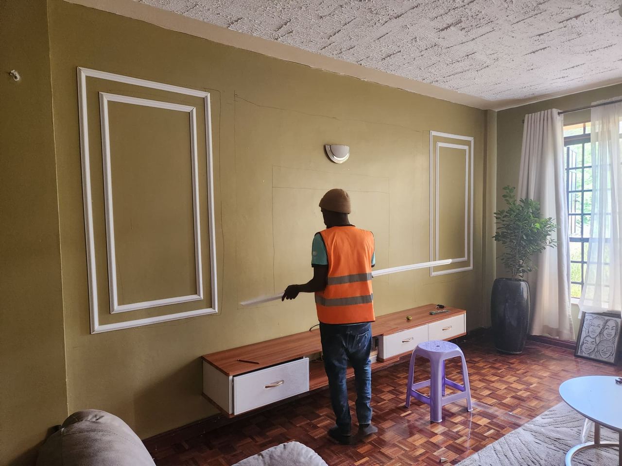 Custom wainscoting installation in progress on a lounge feature wall in Kiambu